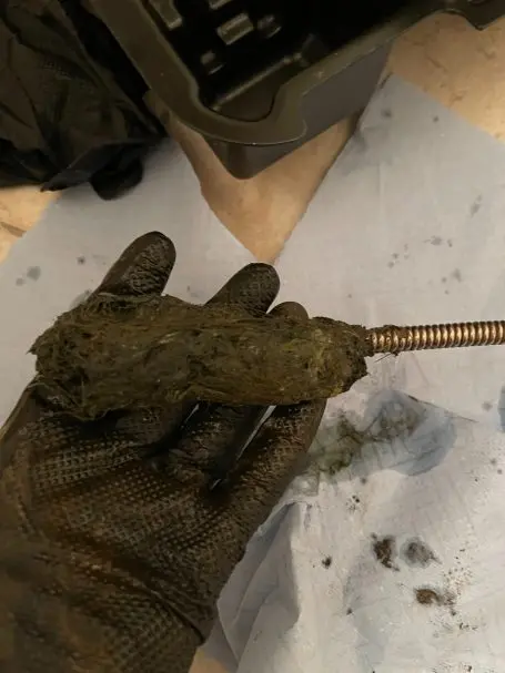 Entfernte Verstopfung aus dem Abfluss einer Duschwanne